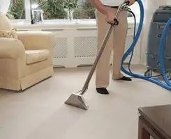 Carpet cleaning professional removing dirt and stains with a hot-water extraction tool in a home, Stockton, CA.